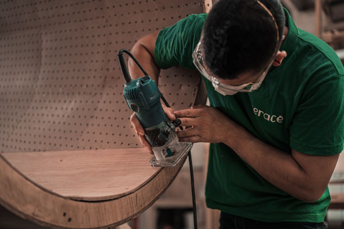 man in green t shirt using router on wooden piece 3637798
